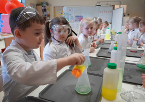 chłopiec nalewa płyn do pojemnika