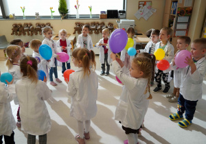 dzieci trzymają kolorowe baloniki