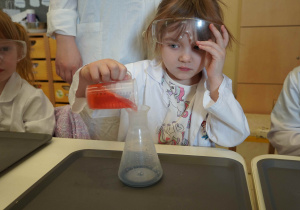 dziewczynka nalewa kolorową substancję