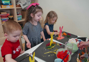 Dziewczynki i chłopiec przyklejają kolorowy mech