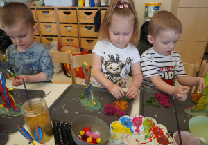 Dziewczynka i chłopcy przyklejają kolorowy mech