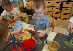 Chłopiec dekoruje swoją pracę