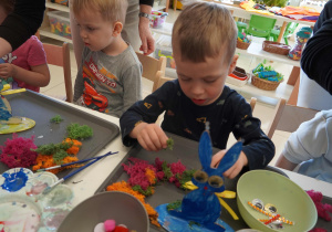 Chłopiec dekoruje swoją pracę