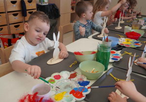 Chłopiec wybiera kolor farby do malowania zająca