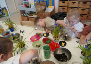 Dzieci wypełniają słoik piaskiem