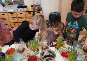 Dzieci wkładają piórka do słoika