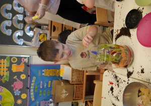 Chłopiec z dumą patrzy na swoją pracę