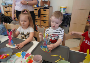 Chłopiec i dziewczynka malują kolorowe figurki