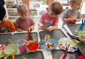 Chłopiec i dziewczynka doklejają oczy zajączkom