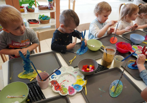 Trzylatki ozdabiają swoje prace