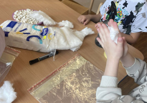 Tymek przygotowuje woreczek do włożenia fasoli