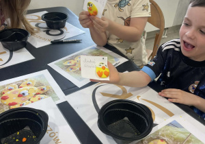 Chłopcy pokazują swoje gotowe kurczaki