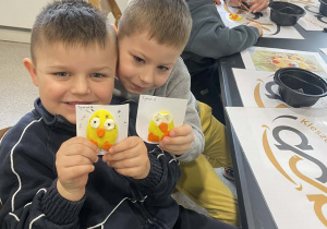 Chłopcu chwalą się swoimi dziełami