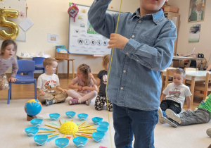 chłopiec nawleka koraliki