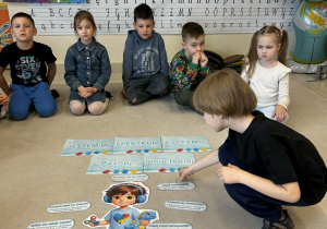 Chłopiec układa plansze na dywanie