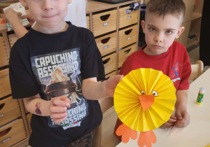 Chłopiec z dumą prezentuje swoją samodzielnie wykonaną ozdobę.