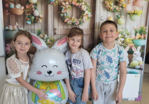 Dzieci pozują do pamiątkowego zdjęcia przy wielkanocnym zajączku.