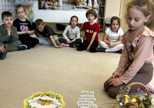 Dziewczynka porządkuje napisy z nazwami produktów do koszyczka.