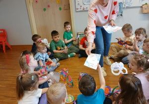 Nauczycielka wręcza dyplomy dzieciom