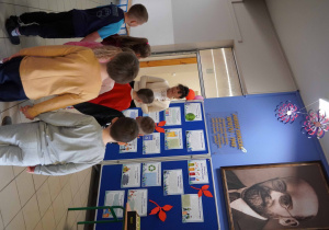 Pani Dyrektor rozmawia z dziećmi przy gazetce ściennej poświęconej Januszowi Korczakowi.