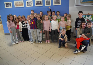 Sześciolatki wraz z Panią Ewą pozują do wspólnego zdjęcia na szkolnym korytarzu