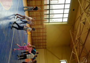 Uczniowie aktywnie uczestniczą w grach i zabawach ruchowych na sali gimnastycznej w szkole