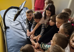Przedszkolaki z zaciekawieniem oglądają nowoczesne łóżko rehabilitacyjne