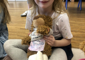 dziewczynka pokazuje zabandażowanego misia