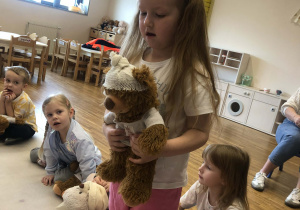 dziewczynka pokazuje zabandażowanego misia