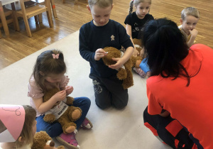 dzieci naklejają misiom plastry