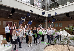 dzieci rzucaja biretami w gurę na zakończenie uniwersytetu