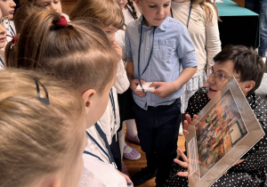 dzieci oglądają zdjęcie trzymane przez Pania dyrektor ZSP