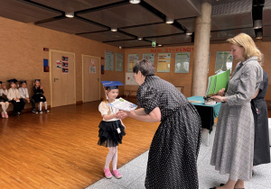 Panie dyrektor wręczają dyplom oraz indeks dziewczynce