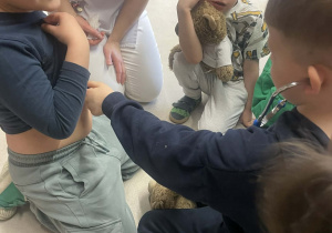 Stasio osłuchuje Tymka stetoskopem