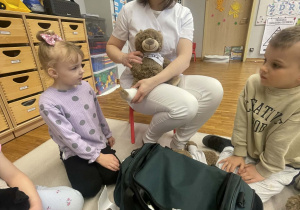 Dzieci badanżują stopę misia