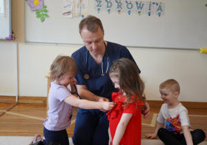 dziewczynka bada stetoskopem koleżankę