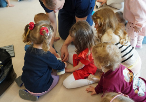 dzieci bandażują chłopcu nogę