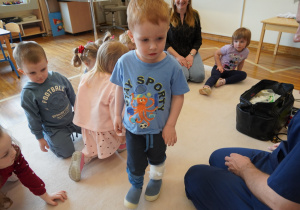 chłopiec pokazuje zabandażowaną nogę