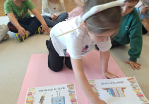 dziecko przykleja kartkę