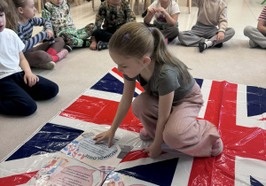 ziewczynka w środku układa kartę z informacja na fladze