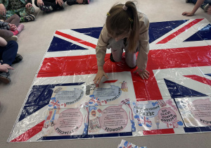 ziewczynka w środku układa kartę z informacja na fladze