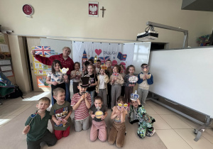 dzieci z Panią pozują z gadżetami związanymi z Wielką Brytanią do wspólnego zdjęcia