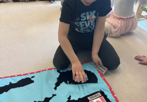 chłopiec przyczepia flagęUSA na macie