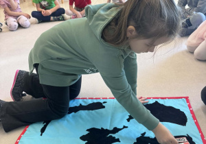 dziewczynka przyczepia falgę Kanady na macie