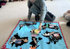 chłopiec przyczepia tradycyjne danie "fish and chips"na mapie Wielkiej Brytanii