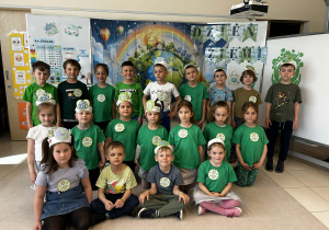 Grupowe zdjęcie 6-latków na tle ekologicznej dekoracji.