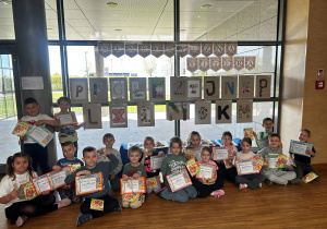 Grupowe zdjęcie dzieci z literami sensorycznymi i dyplomami