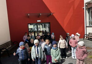 Grupowe zdjęcie przed budynkiem szkoły