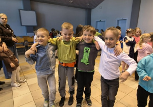 Chłopcy trzymają się za szyję i tańczą