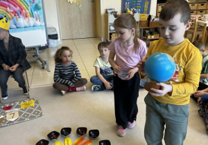 Chłopiec trzyma globus a dziewczynka rozkłada koraliki